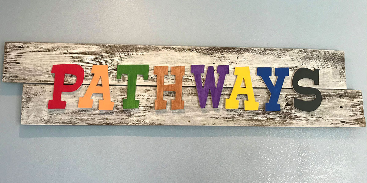 A wooden sign spelling out Pathways.