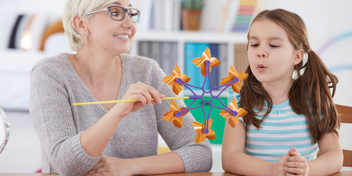 a Pediatric Therapist doing a specialized activity with a child.